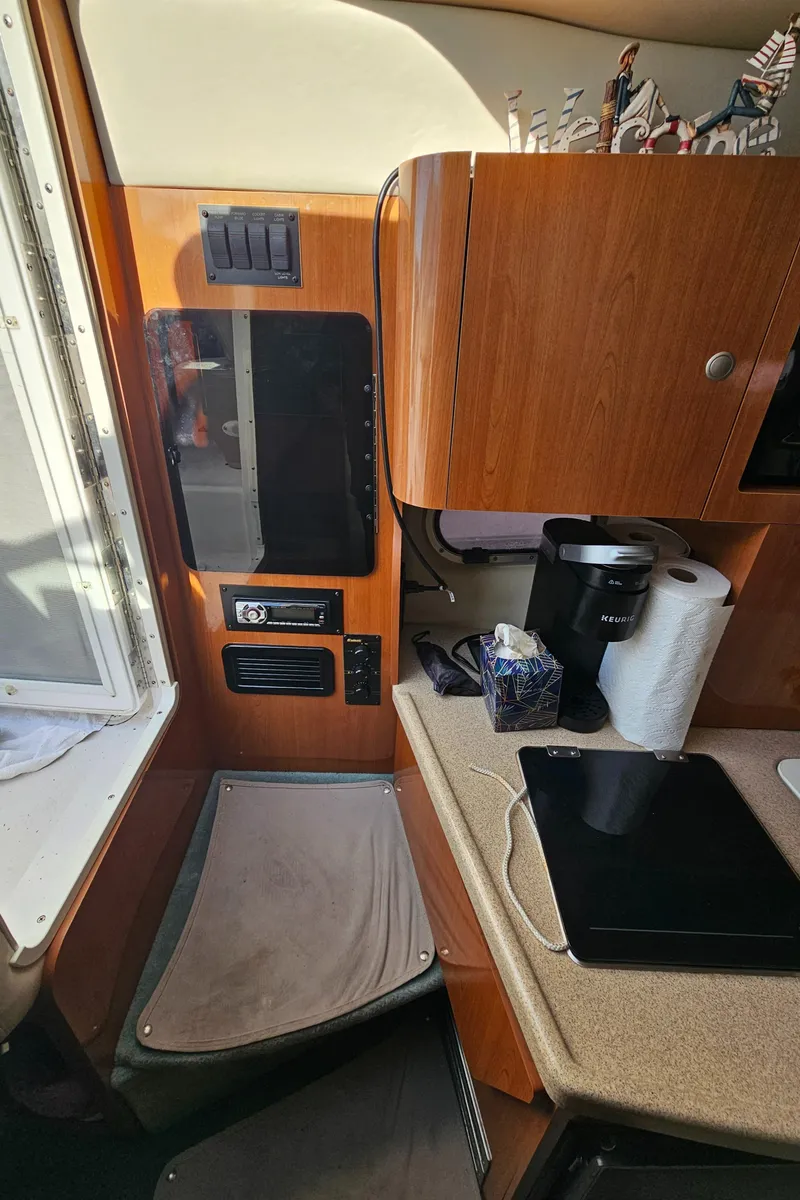 Slide: The Image of Interior of 2002 Four Winns 248 Vista boat with kitchenette and seating area. - 13