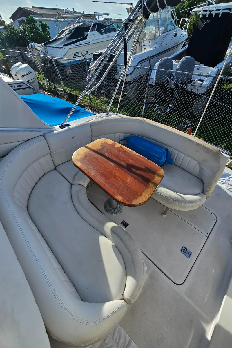 Slide: The Image of 2002 Four Winns 248 Vista boat with cushioned seating and wooden table. - 17