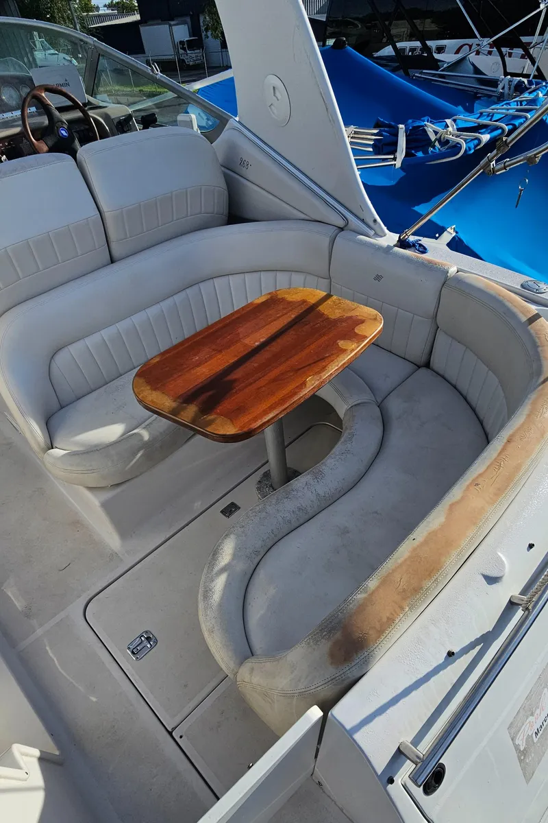 Slide: The Image of 2002 Four Winns 248 Vista boat interior with seating and wooden table. - 18