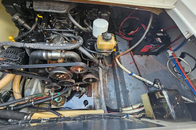 Slide: The Image of Engine compartment of 2002 Four Winns 248 Vista boat, showing mechanical components and battery. - 19