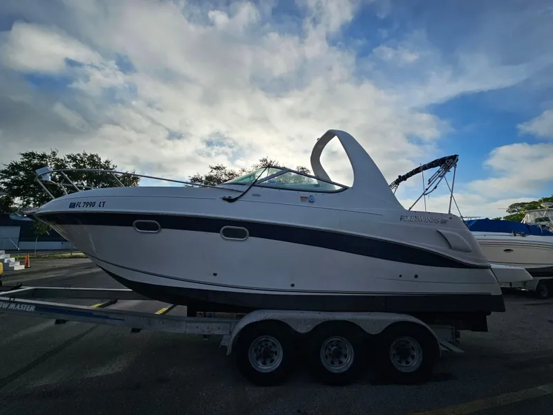 Slide: The Image of 2002 Four Winns 248 Vista boat on trailer under cloudy sky. - 2