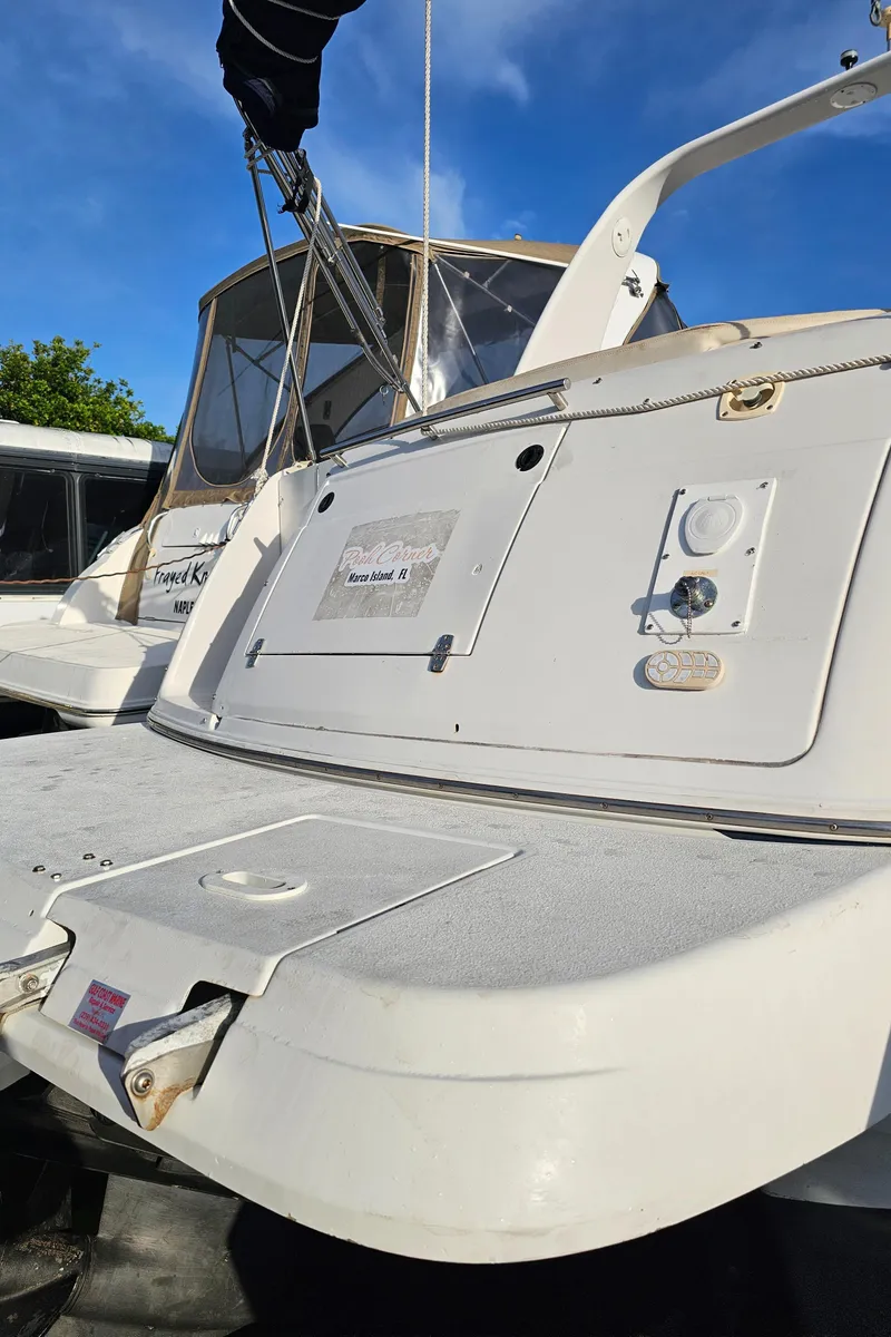Slide: The Image of 2002 Four Winns 248 Vista boat, rear view, docked under clear blue sky. - 21