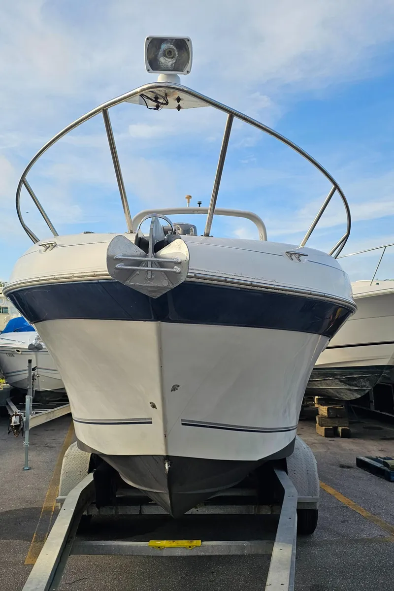 Slide: The Image of 2002 Four Winns 248 Vista boat on trailer, front view, under blue sky. - 3