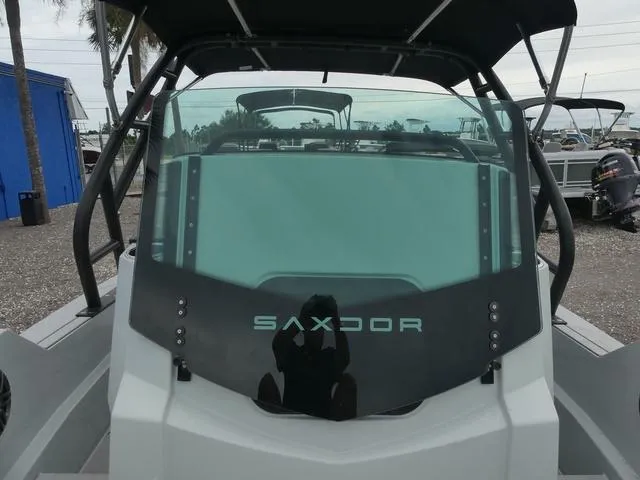 Slide: The Image of 2022 Saxdor SX 200 boat with sleek windshield design, docked outdoors. - 20