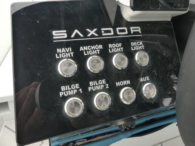 Slide: The Image of Control panel of 2022 Saxdor SX 200 boat with various light and pump switches. - 23