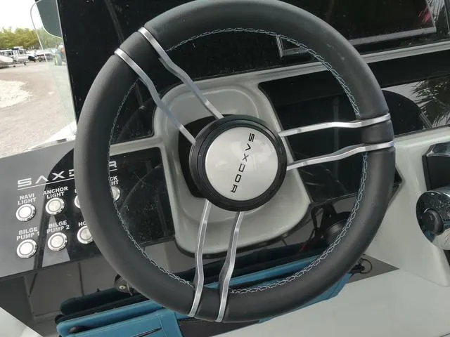 Slide: The Image of 2022 Saxdor SX 200 steering wheel and control panel close-up. - 24