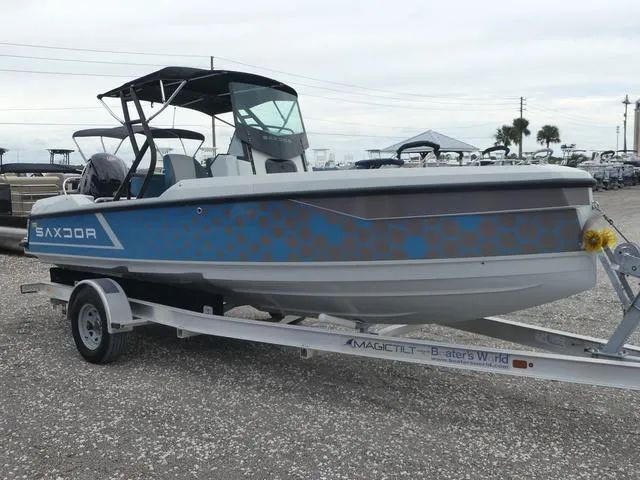 Slide: The Image of 2022 Saxdor SX 200 boat on trailer, blue and gray design, parked outdoors. - 6
