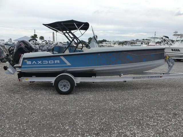 Slide: The Image of 2022 Saxdor SX 200 boat on trailer, blue and gray design, parked outdoors. - 7