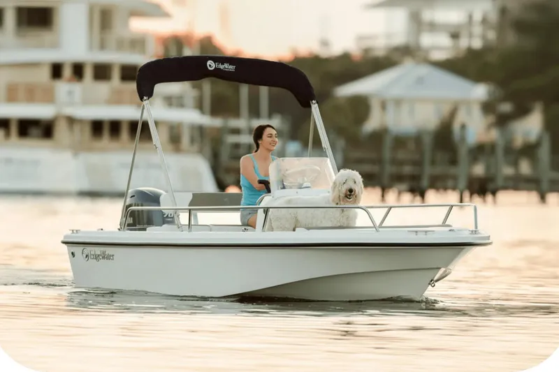 Slide: The Image of Woman and dog on Edgewater 158CS boat, 2026 model, at sunset. - 6