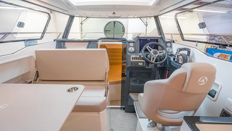 Slide: The Image of Interior of 2024 Skamander 920 Explorer MAX boat, featuring modern helm and seating area. - 14