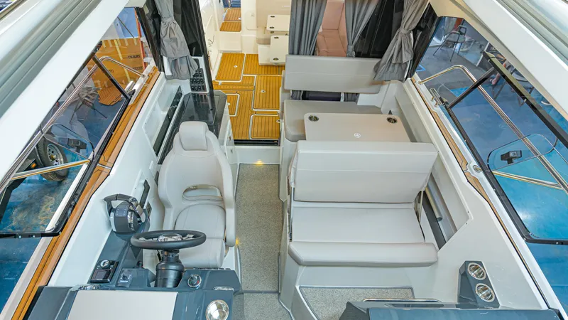 Slide: The Image of Interior of 2024 Skamander 920 Explorer MAX boat, featuring modern seating and steering area. - 19