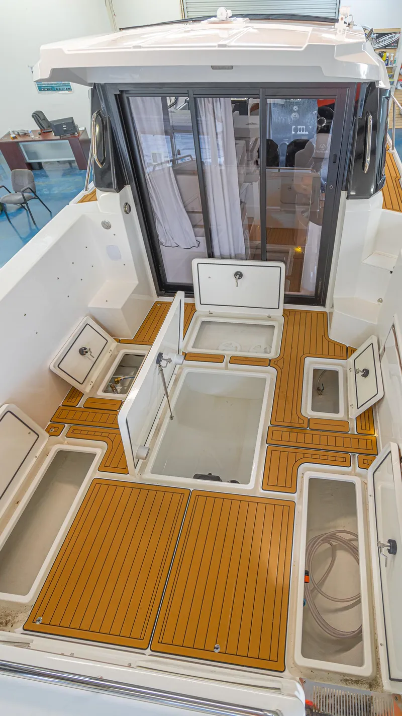 Slide: The Image of 2024 Skamander 920 Explorer MAX boat interior with open storage compartments. - 21