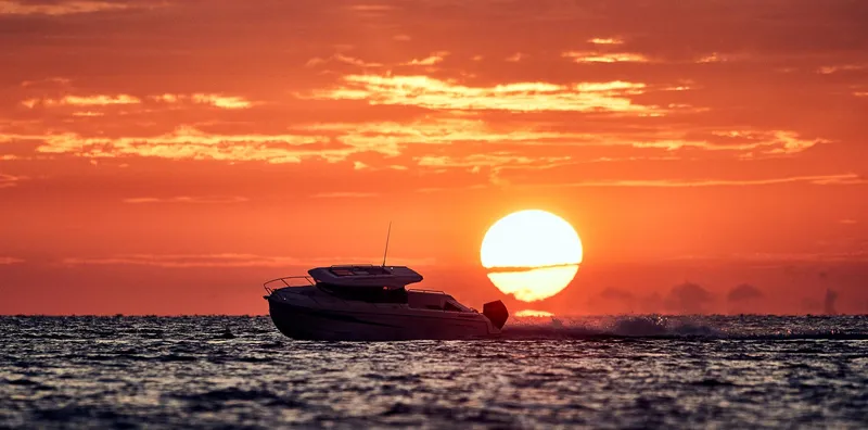 Slide: The Image of 2024 Skamander 920 Explorer MAX boat cruising at sunset on the ocean. - 24