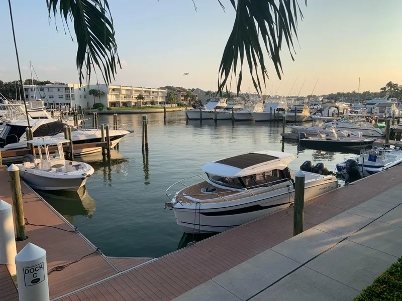 Slide: The Image of 2024 Skamander 920 Explorer MAX docked in a serene marina at sunset. - 3