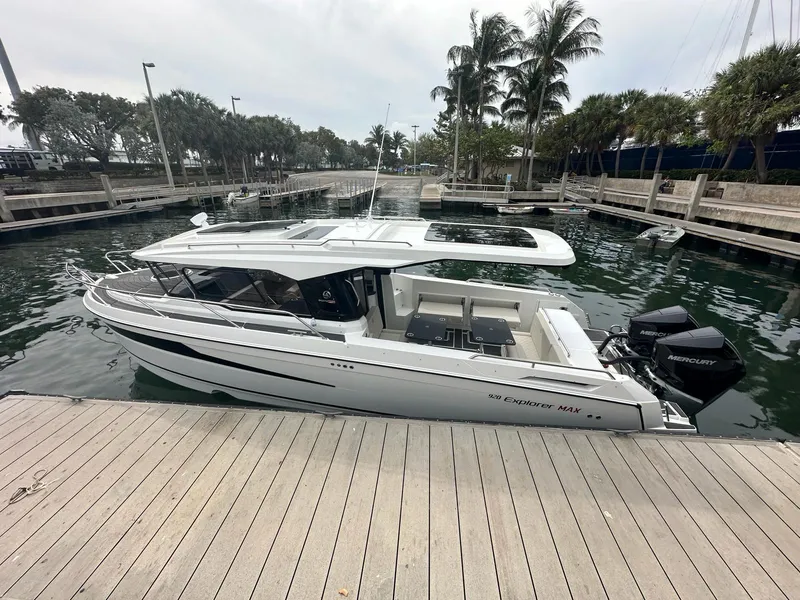 Slide: The Image of 2024 Skamander 920 Explorer MAX boat docked at marina with palm trees. - 38