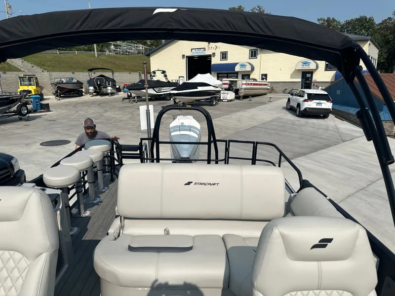 Slide: The Image of Starcraft RX 25 DL DC 2025 pontoon boat at marina with seating and canopy. - 12