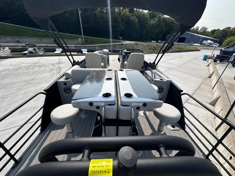 Slide: The Image of 2025 Starcraft RX 25 DL DC boat interior with seating and tables, docked outdoors. - 16