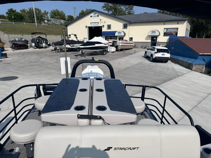 Slide: The Image of 2025 Starcraft RX 25 DL DC boat at a marina with other boats and vehicles. - 17