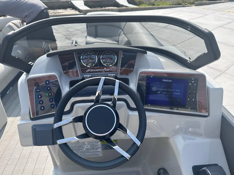 Slide: The Image of 2025 Starcraft RX 25 DL DC boat dashboard with steering wheel and digital display. - 3