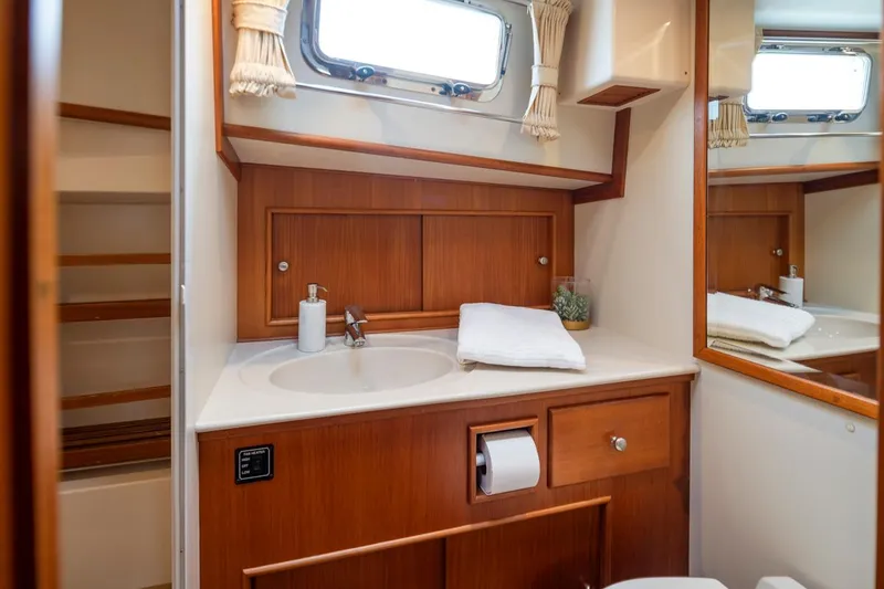 Slide: The Image of Luxurious 2003 Grand Banks Eastbay 54 SX yacht bathroom with wooden cabinetry and modern fixtures. - 21