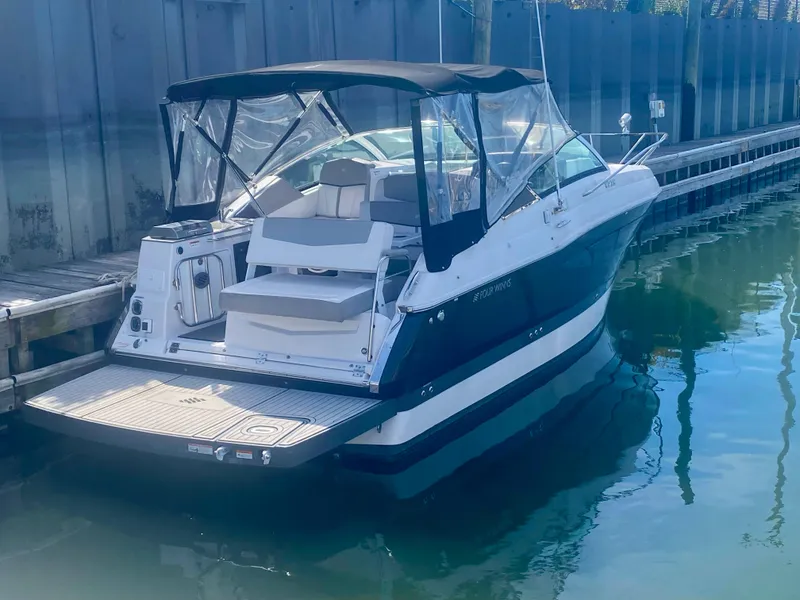 Slide: The Image of 2019 Four Winns Vista 275 boat docked in marina, featuring sleek design and canopy. - 1
