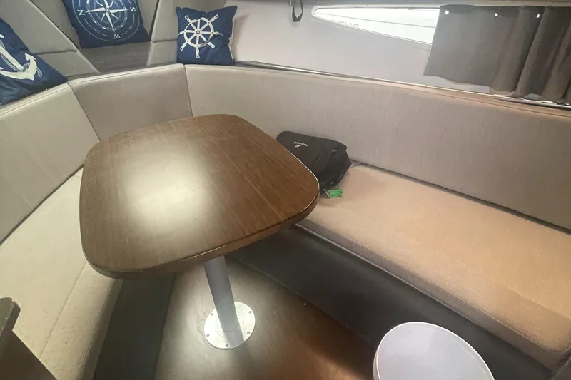 Slide: The Image of 2019 Four Winns Vista 275 interior with cozy seating and wooden table. - 32