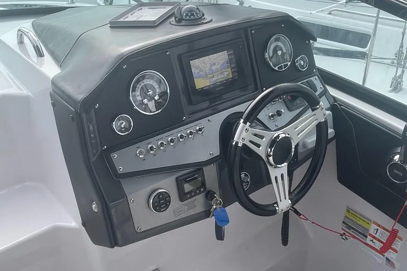 Slide: The Image of 2019 Four Winns Vista 275 dashboard with steering wheel and navigation display. - 36
