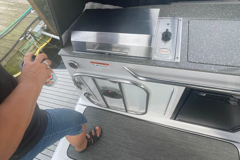 Slide: The Image of Person standing near outdoor kitchen on 2019 Four Winns Vista 275 boat. - 41