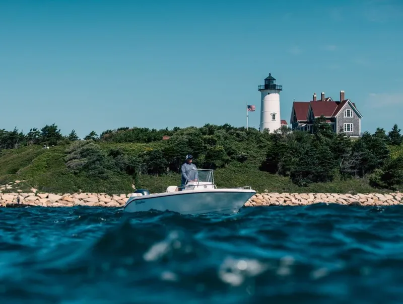 Slide: The Image of Edgewater 170CC boat on ocean near lighthouse, 2025 model. - 1