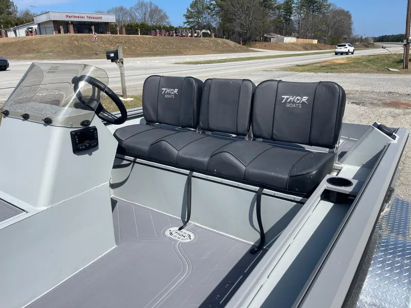 Slide: The Image of 2024 Thor 1860 Lake Hammer Side Console boat with black seating and steering console. - 4