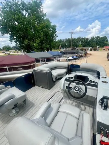 Slide: The Image of 2022 Manitou 23OASIS VP II pontoon boat with sleek gray seating and modern dashboard. - 4