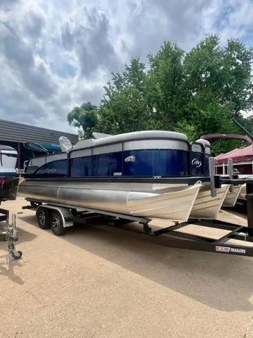 Slide: The Image of 2022 Manitou 23OASIS VP II pontoon boat on trailer, parked outdoors under cloudy sky. - 6