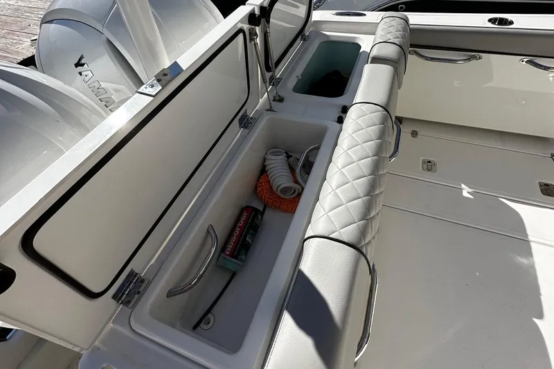 Slide: The Image of 2022 Pursuit DC 295 Dual Console boat interior with storage compartments and seating. - 11