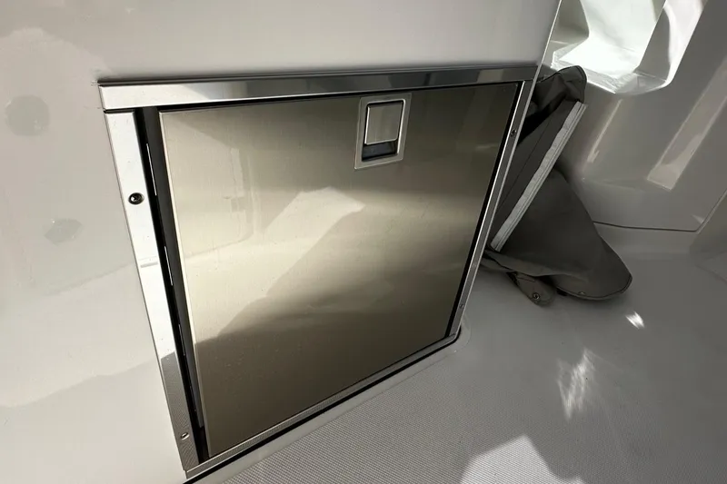Slide: The Image of Stainless steel compartment on 2022 Pursuit DC 295 Dual Console boat interior. - 13