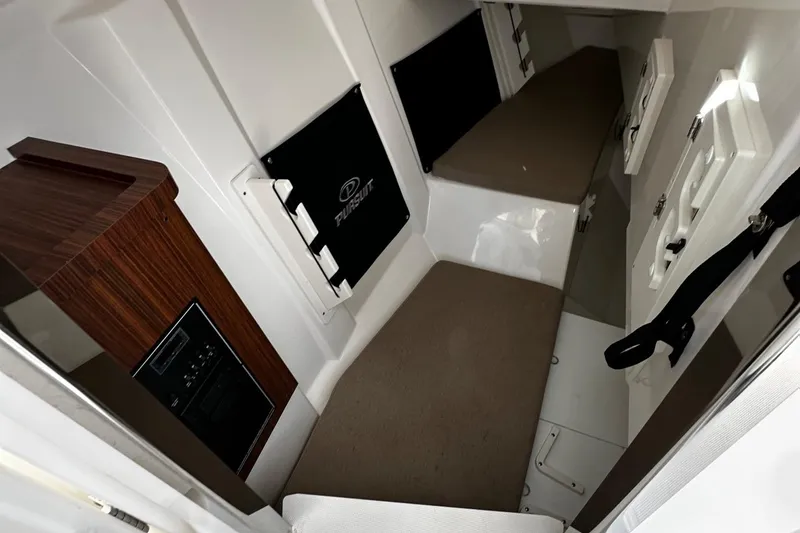 Slide: The Image of 2022 Pursuit DC 295 Dual Console cabin interior with seating and storage. - 16