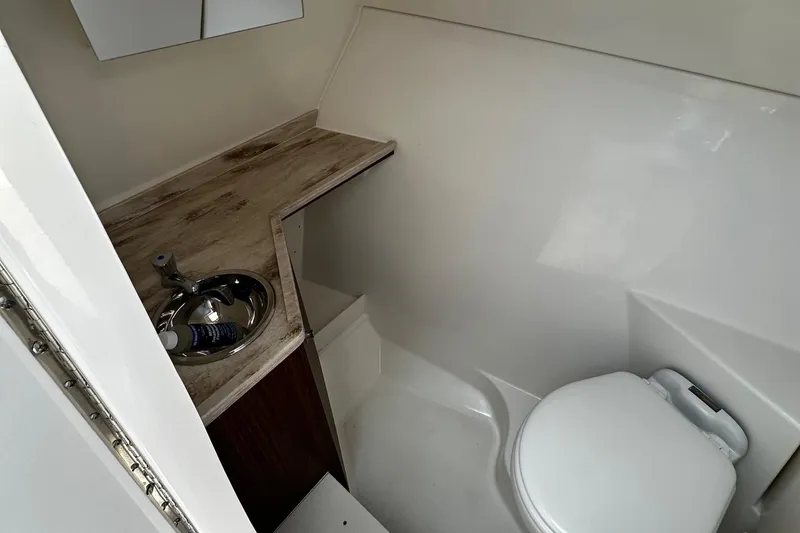 Slide: The Image of 2022 Pursuit DC 295 Dual Console boat bathroom with sink and toilet. - 17