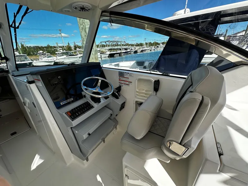 Slide: The Image of 2022 Pursuit DC 295 Dual Console boat interior with steering wheel and seating. - 4