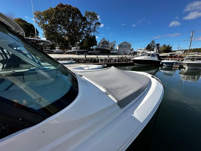 Slide: The Image of Pursuit DC 295 Dual Console 2022 boat docked in a marina under clear blue skies. - 7