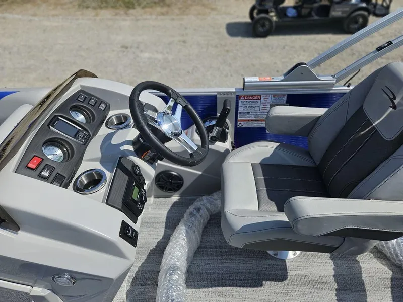 Slide: The Image of 2025 Bennington 22 SXSB boat cockpit with steering wheel and captain's chair. - 7