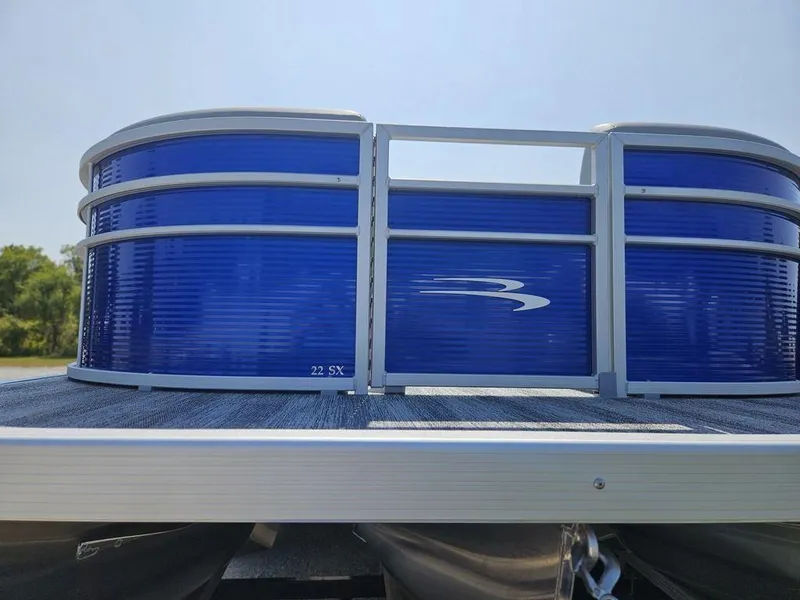 Slide: The Image of 2025 Bennington 22 SXSB pontoon boat with blue paneling and sleek design. - 9