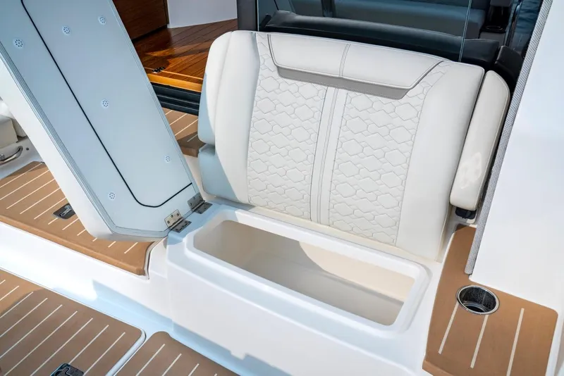 Slide: The Image of 2025 Tiara Yachts 48 LE seat storage compartment, luxury design, white upholstery. - 17