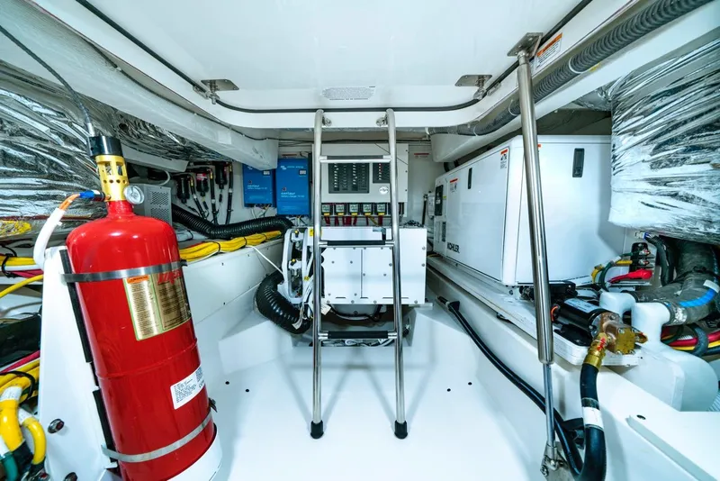 Slide: The Image of Engine room of 2025 Tiara Yachts 48 LE, featuring equipment and fire extinguisher. - 32