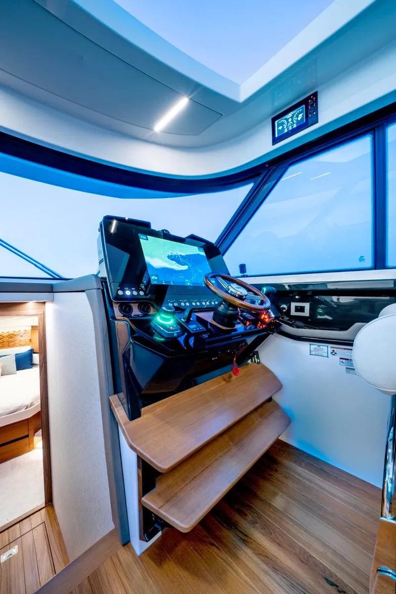 Slide: The Image of 2025 Tiara Yachts 48 LE helm with modern navigation controls and wooden flooring. - 38
