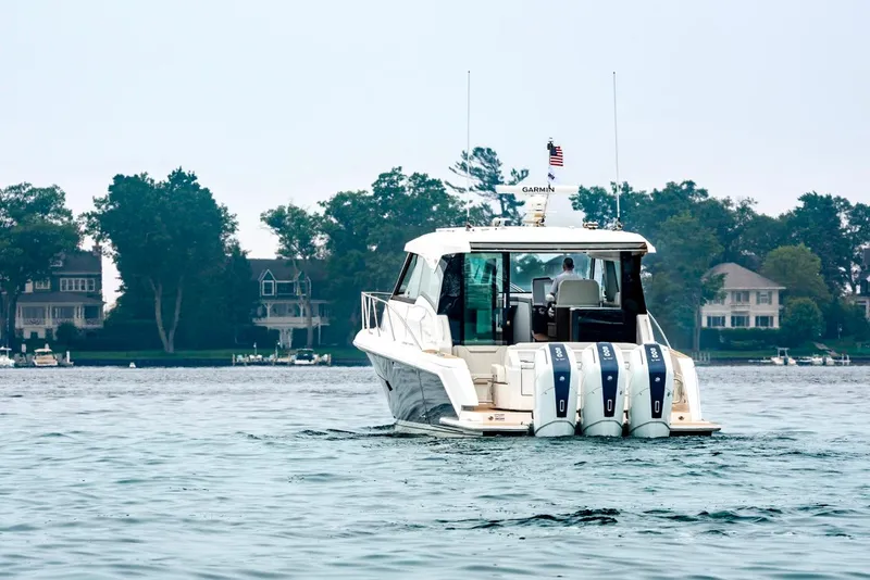 Slide: The Image of 2025 Tiara Yachts 48 LE cruising on a serene lake. - 4