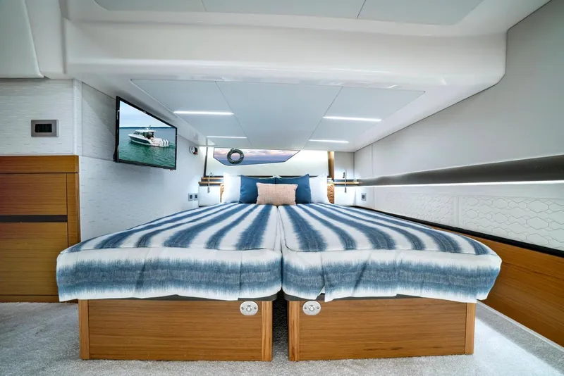 Slide: The Image of Luxurious 2025 Tiara Yachts 48 LE cabin interior with striped bedding and modern decor. - 48