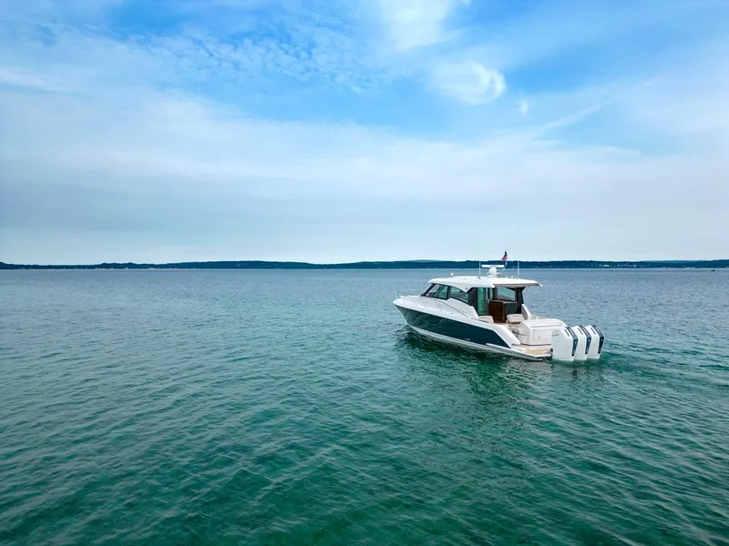 Slide: The Image of 2025 Tiara Yachts 48 LE cruising on open water under a clear blue sky. - 5