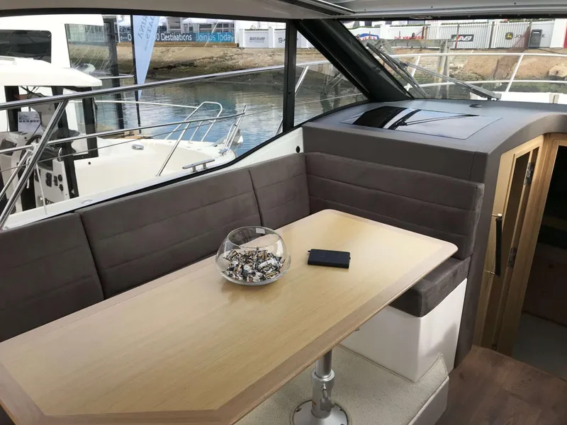 Slide: The Image of Interior of 2025 Skamander Monaco Coupe yacht with table and seating area. - 11