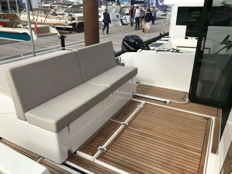 Slide: The Image of 2025 Skamander Monaco Coupe yacht with sleek seating and teak deck at a marina. - 12