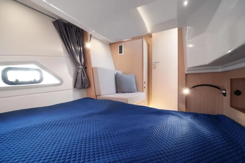 Slide: The Image of Interior of 2025 Skamander Monaco Coupe, featuring a cozy cabin with blue bedding. - 20