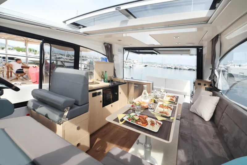 Slide: The Image of Luxurious interior of 2025 Skamander Monaco Coupe yacht with dining setup and marina view. - 22